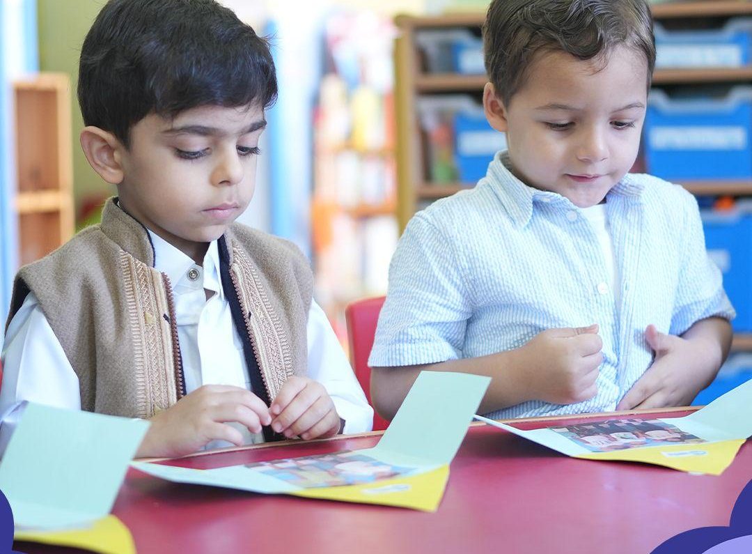 Two boys looking through activity cards together at a classroom table