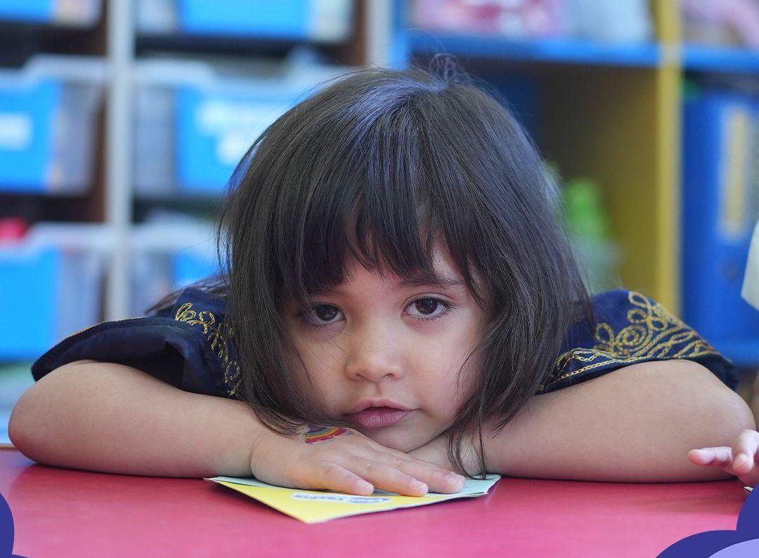 A child concentrating quietly at her table during class