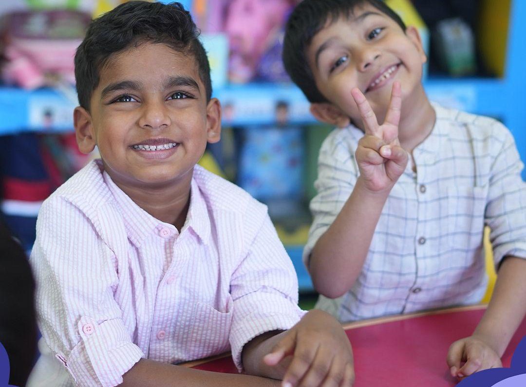 Two preschool boys sitting together, laughing